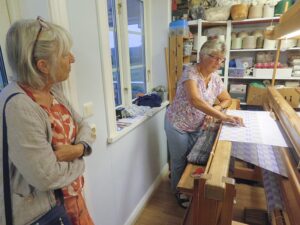 Anna shows us a newly woven daldräll tablecloth in her studio
